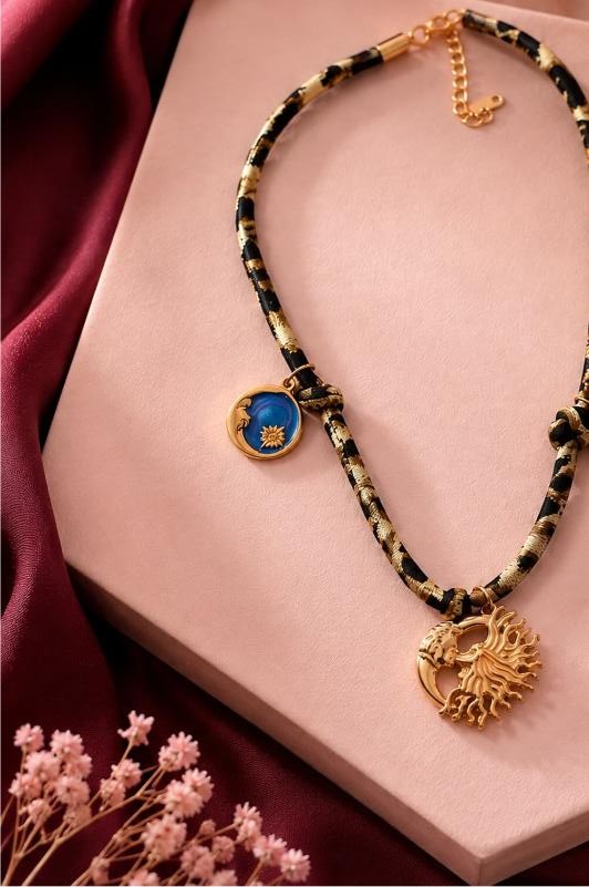 Hélios — black-and-gold braided cord choker with blue sun and gold sunburst medallions